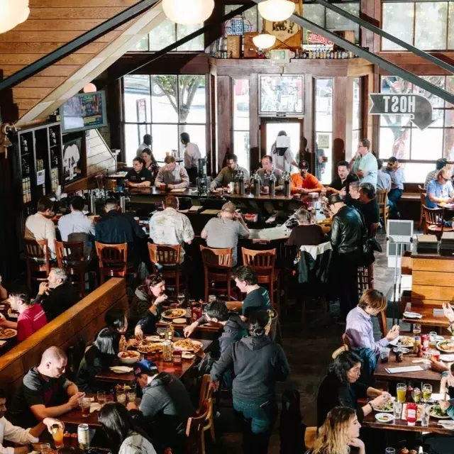 Patrons eat and drink inside the 21st Amendment Brewery 在贝博体彩app.